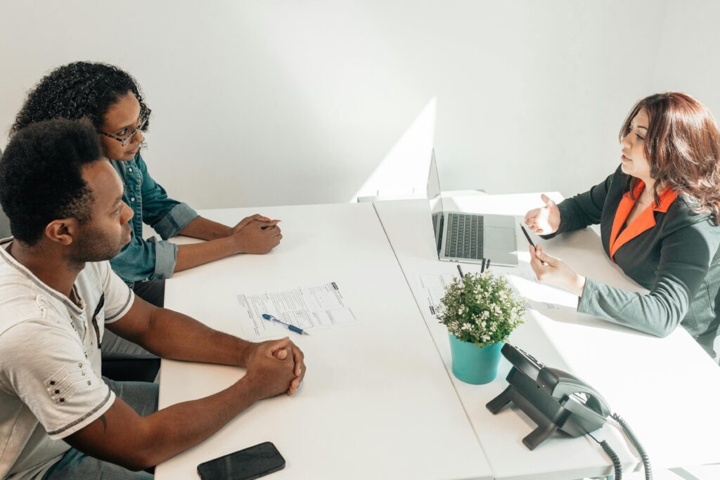 Two adults consulting a legal advisor in a modern office setting.